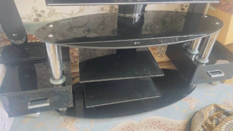 A piece of TV table made of glass is healthy and without breakage, black color, price 3000,000, please contact Joramed on 0799294595